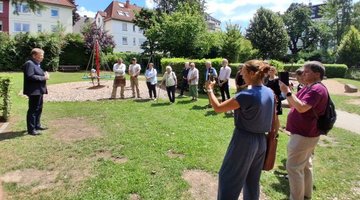 Auf dem Bild sieht man Bürgermeister Frank Hasenberg und eine Gruppe von Menschen, die im Halbkreis steht.